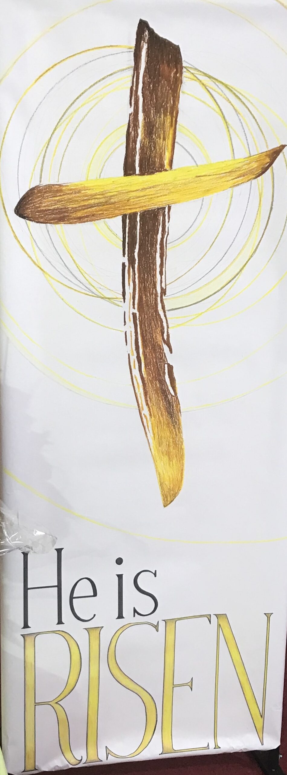 A banner showing a cross with the text, "He is risen."